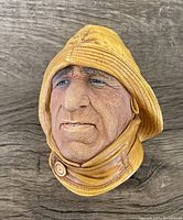 Detailed front view of fisherman head with yellow rain hat and coat collar showing textured wrinkles and facial expression