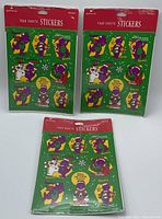 Three unopened Barney sticker packs, each containing four sheets of stickers with Barney and related characters on a green background.