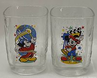 Photo showing two clear drinking glasses with colorful 2000 Disney McDonald's Mickey Mouse themed prints.