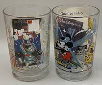 Photo of two Disney collector glasses featuring Donald Duck, Mickey Mouse, and Pluto with colorful promotional designs.