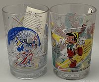 Photo of two Disney-themed glasses showing detailed artwork of Pinocchio and Mickey Mouse.