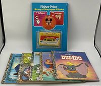 Fisher Price Library of Storytapes & Books with multiple storybooks featuring Disney characters and a cassette tape in packaging.