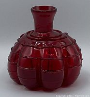 Photo showing vintage red glass figure with bulbous segmented design and flared neck opening.