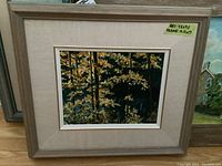 Framed oil painting with a linen mat showing yellow-leafed trees in a forest. Label notes artwork dimensions as 7.5x9.5 and frame as 15.5x17.