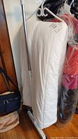 White duvet standing upright on a clothing rack, showing the full length and thickness.