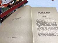 Open book view showing the title page and first chapter of The North Point Cabin Mystery by Capwell Wyckoff, copyright 1932.