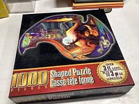 Box of 1000-piece dragon shaped puzzle sealed in plastic wrap showing the puzzle artwork and branding.