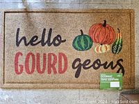 Photo of rectangular outdoor door mat with fall theme, colorful pumpkins and gourds, and text "hello GOURD geous".