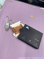 Image of the open box fairy lights showing copper wire string lights and USB connector, alongside the black labeled packaging box.