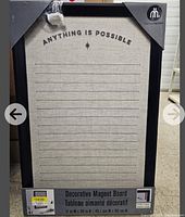 Photo of a new decorative magnetic board with a black frame and fabric surface displaying 'ANYTHING IS POSSIBLE' text and horizontal lines for notes.