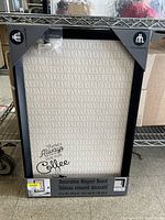 Photo of boxed decorative magnetic board with coffee theme text and House Trends branding.