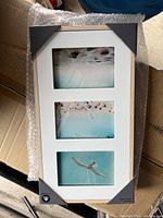 Front view of the wooden photo frame holding 3 photos with white mat and black corner protectors