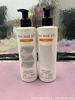 Front view of two white pump bottles labeled The Nue Co Hair Supa Thick Shampoo and Supa Thick Conditioner, each 250 ml.