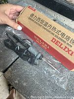 Photo showing Delixi soldering iron with attached cord and original cardboard box labeled in Chinese and English as Senior Constant Temperature Soldering Iron model HG-118X.