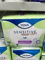 Package of TENA Sensitive Care Extra Coverage pads showing the front where the product name, brand, quantity (12 pads), and absorbency level are visible.