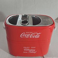 Front view showing red Coca-Cola branding and slogan on the toaster body.