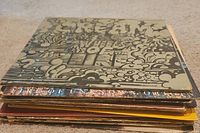 Stacked vinyl records with the top one being Cream's Wheels of Fire album with a psychedelic art cover.