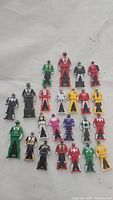 Twenty-five Power Rangers Mega Force keys arranged on a white surface showing the front detailed Ranger figurines in multiple colors.