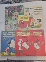 Seven vintage children's books stacked with visible front covers on a fabric surface.