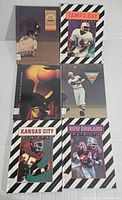 Top view of 6 sports books featuring football teams Tampa Bay Buccaneers, Kansas City Chiefs, New England Patriots, Cleveland Indians baseball, Seattle Supersonics basketball