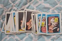 Image showing a spread of WWF wrestling trading cards stacked and scattered on a fabric surface with various colored borders and labels visible.