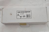 White rectangular box labeled 'Loaner Spring Compressor OEM# 27035, Made in Taiwan' showing product packaging.