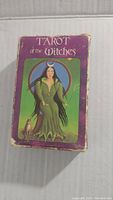 Box front showing witch figure, cat, and moon against green and purple background with text 'Tarot of the Witches'. Box edges show wear.