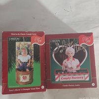 Photo of two boxed I Love Lucy heirloom ornaments by Carlton Cards, showing front of boxes with titles and images of ornaments.