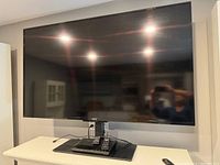 Front view of Sony 55-inch TV on stand with remote on base