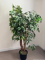 Artificial tree about 4 feet tall with lush green leaves and multiple wooden stems in a black pot