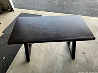 Top view of solid wood table showing smooth rectangular dark wood surface with visible grain.