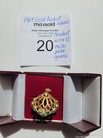 Pendant in red velvet jewelry box next to seller’s handwritten note reading '14kt Gold Basket Weave Pendant with 12 milk jade gems'
