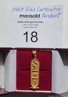 Pendant centered in red-velvet jewelry box showing overall appearance and design against printed lot card.