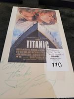 Photo of Titanic movie poster with autograph by James Cameron, showing full poster and signature at bottom.