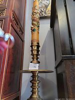 Full view of the tall Chinese candle mounted on the brass drip plate stand with carved teak base.