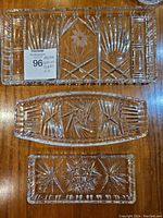 Top view of all three crystal serving plates stacked for display, highlighting their intricate cut patterns and clear heavy crystal material.