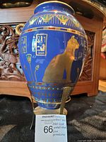 Side view of blue porcelain vase with gold cat and decorative Egyptian designs with gold embellishment