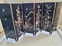 Full view of the six-panel black lacquered decorative screen with reflective mother of pearl inlay of floral and butterfly motifs