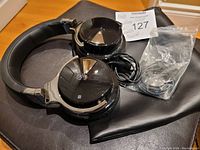 Cowin black noise canceling headphones with ear cups and headband, charging cable, and carrying case pouch