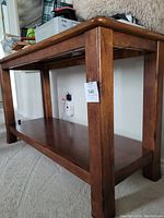 Side view showing table legs and sturdy wooden lower shelf, rich brown finish
