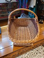 Front view of the large rectangular wicker basket showing the handle and woven details.