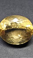 Close-up photo of the oval cut golden citrine gemstone showing color, facet pattern, and clarity.