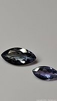 Two marquis cut natural Tanzanite gemstones showing their color, cut and clarity.