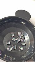Image showing multiple rainbow-colored round faceted Mystic Topaz gemstones in a black round tray.