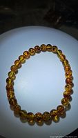 Top view of the natural Baltic amber piebald bracelet showing the polished round beads strung on stretchy cord.