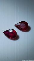 Close-up of two pear-shaped natural rubies with rich blood red color, facets visible
