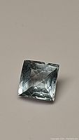 Clear photo showing square cushion-shaped aquamarine with checkerboard cut facets, highlighting color and clarity.