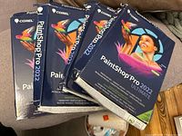 Four boxed copies of Corel PaintShop Pro 2022 Ultimate with damaged outer packaging.