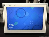 Front view of Facebook Portal device powered on, showing home screen with time and date.
