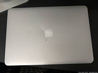Top lid of Apple MacBook Pro showing silver finish and a small dent near the Apple logo.